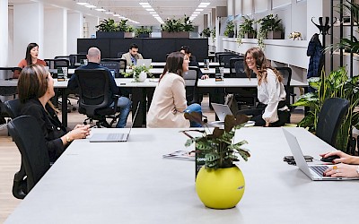 Menschen sitzen in einem Coworking Space und unterhalten sich