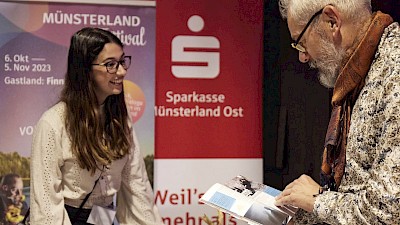 Gastland trifft auf das Münsterland - ein Besucher blättert durch das Programmheft.