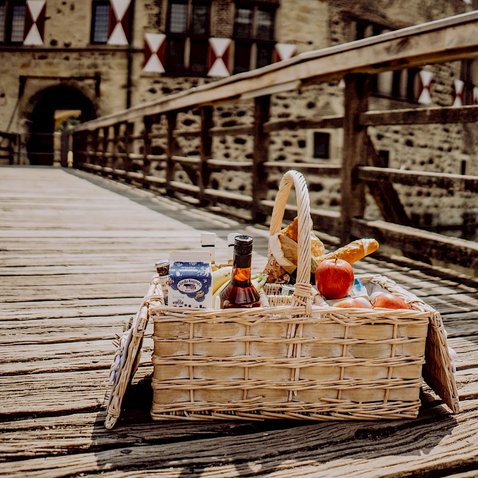 A packed picnic basket in front of Vischering Castle