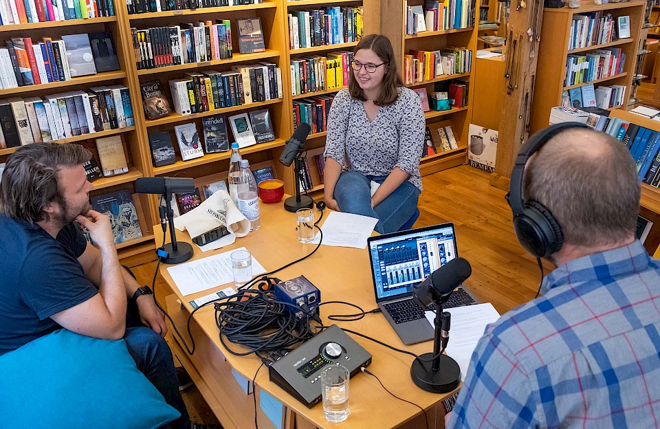 Podcast recording between bookshelves